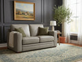 Light gray loveseat with clean lines, upholstered in soft leather or fabric, placed in a modern living room.