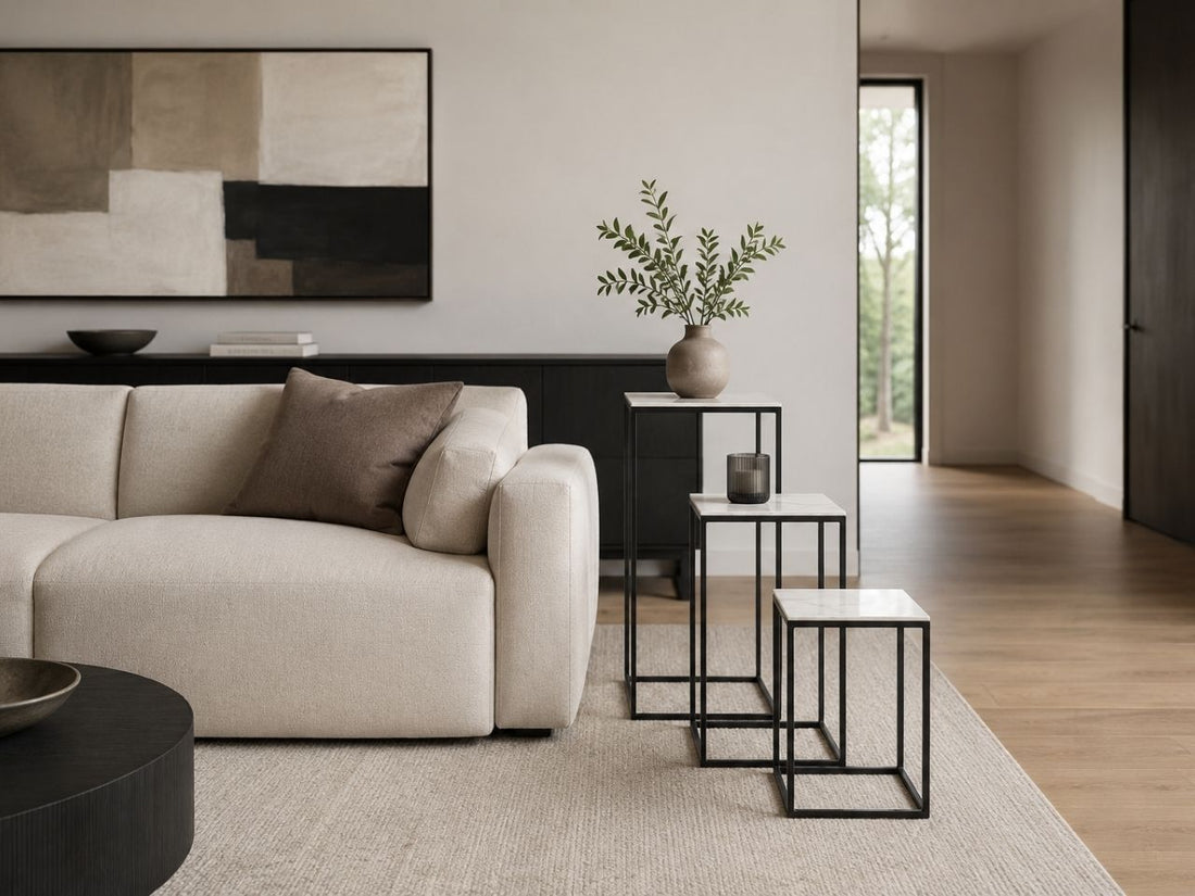 Marble pedestal side table set beside a cream sofa in a modern living room.