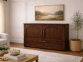 Dark wood cabinet bed with arched paneled doors and brass handles, styled in a warm, classic living room.