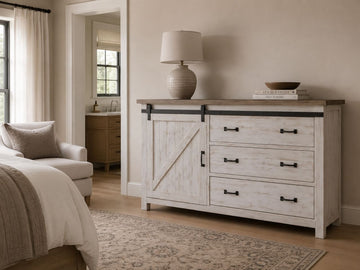 Whitewashed farmhouse dresser with sliding barn-door detail, distressed finish, black metal hardware, and rustic country-inspired charm.