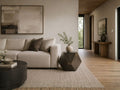Geometric metal side table beside a cream sofa in a modern living room.