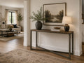 Dark wood console table styled in a warm modern entryway with neutral décor.