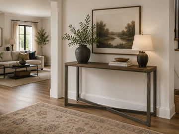 Dark wood console table styled in a warm modern entryway with neutral décor.