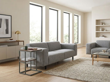 Modern accent table beside a gray sofa in a bright contemporary living room.