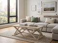 Blonde wood rectangular coffee table with an open geometric base, styled in a bright and modern living room.