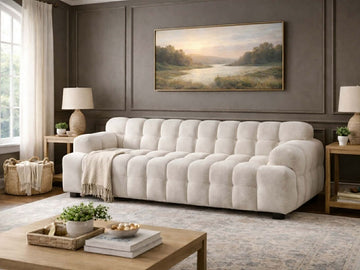 Tufted sofa upholstered in textured fabric, styled in an elegant living room with neutral décor.