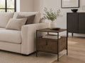 Dark wood end table with a drawer, open shelf, and black metal frame, styled beside a cream sofa in a contemporary living room.