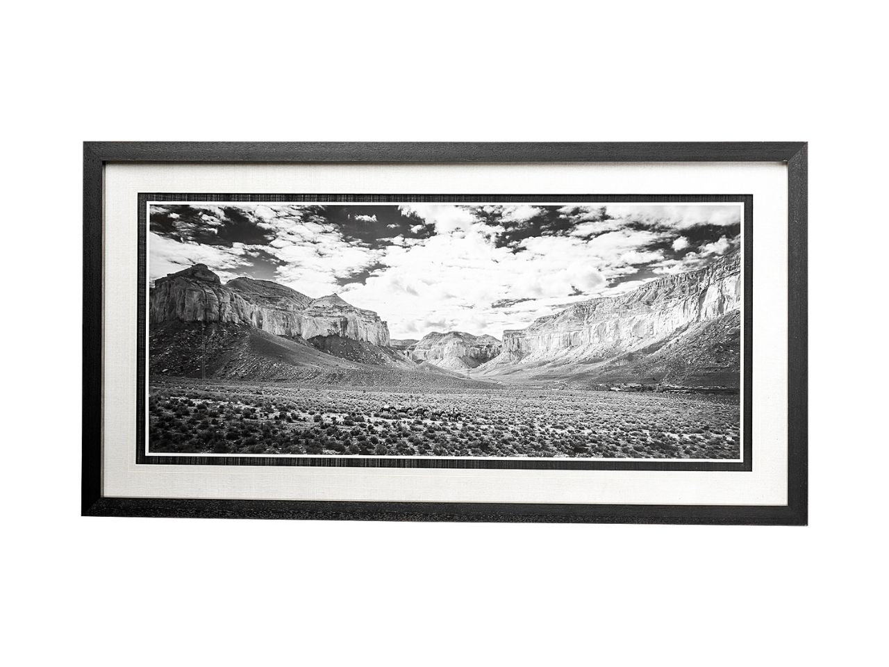 Framed black and white landscape print of a canyon with mountains and clouds.