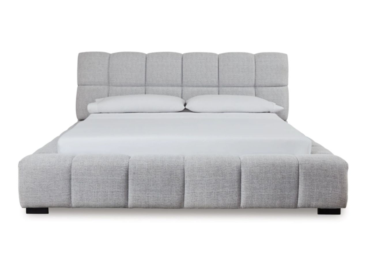 Light gray upholstered bed with tufted headboard and white bedding, front view.