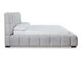 Side profile of light gray upholstered bed with low padded rails.