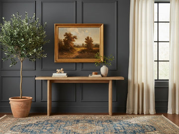 The Grier Console Table is a minimalist, rectangular furniture piece featuring a light-toned natural wood grain.