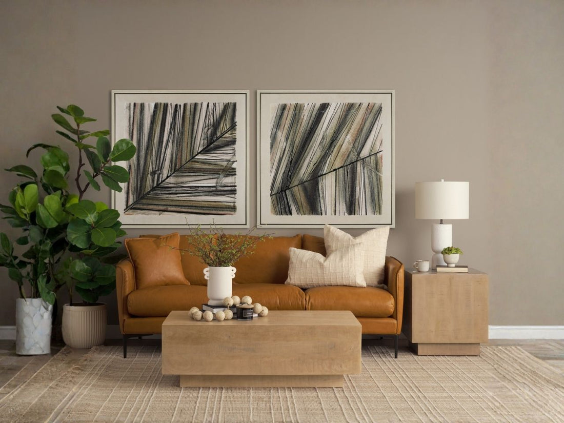 Modern living room with a tan leather sofa, light wood coffee table and side table, abstract wall art, and neutral decor.