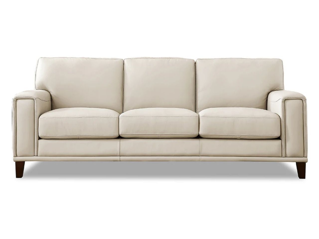A contemporary three-seat leather sofa featuring clean lines, wide arms, and plush cushions, upholstered in a soft off-white leather and shown against a white background.
