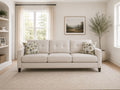 Cream upholstered sofa with patterned accent pillows in a bright, cozy living room.