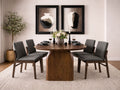 Oval dark wood dining table with sculptural pedestal base, paired with gray upholstered dining chairs in a modern dining room.
