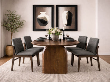 Oval dark wood dining table with sculptural pedestal base, paired with gray upholstered dining chairs in a modern dining room.