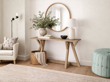 A rustic, light-wood console table with a rectangular top and architectural angled legs.