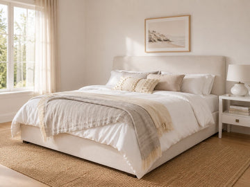 Cream upholstered storage bed with a soft modern design in a bright, cozy bedroom.