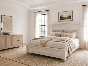 Whitewashed panel bed with a storage footboard in a bright farmhouse-style bedroom.