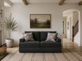 Dark smoke gray loveseat with patterned accent pillows in a modern cozy living room.