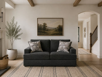 Dark smoke gray loveseat with patterned accent pillows in a modern cozy living room.