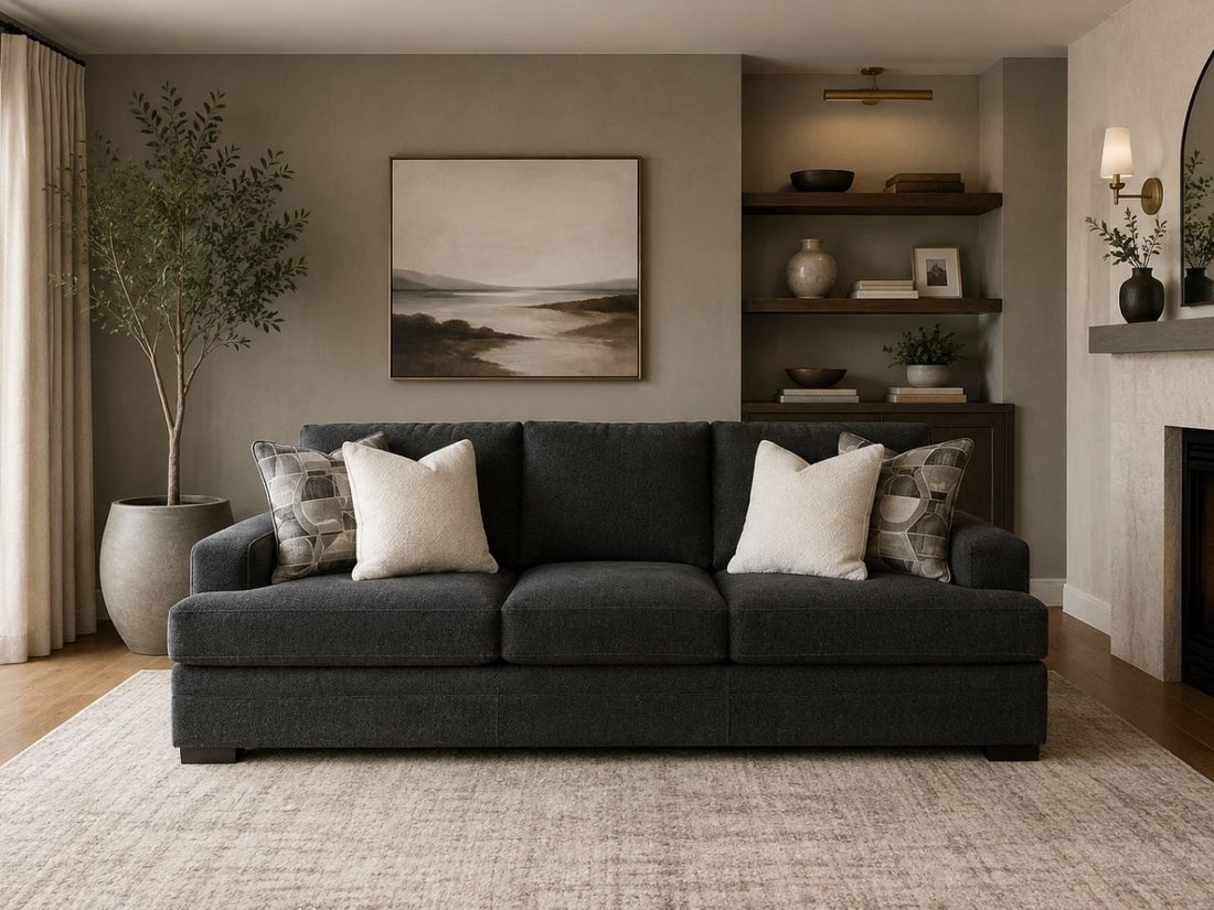 Modern charcoal grey sofa with plush cushions in a luxurious living room. 
