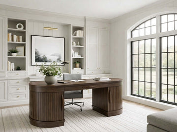 A large, oval-shaped executive desk in dark wood with tambour-style ribbed pedestals.