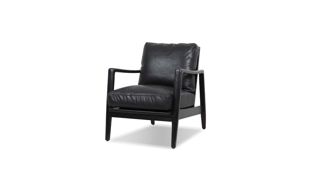 Black leather accent chair in a modern neutral living room.