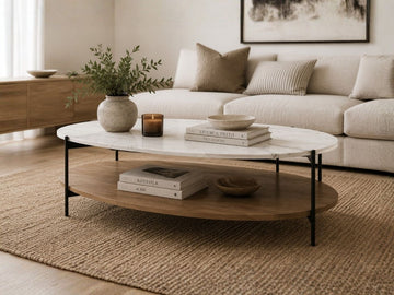 Oval coffee table with a white marble-look top, wood shelf, and black metal frame in a modern living room.