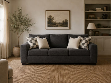Dark fabric sofa with patterned accent pillows in a warm, modern living room.