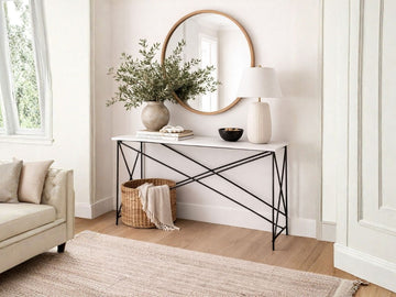 A modern, minimalist console table featuring a slim white rectangular top and a black metal frame with a complex, geometric "X" cross-base design.