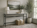 A minimalist console table with a rectangular white marble top and a black metal frame featuring an X-crossbar design.