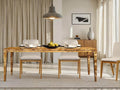 Rectangular burl wood dining table styled with chairs in a bright dining room.