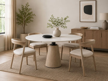 Round white dining table with four upholstered wood-frame chairs in a modern dining room.