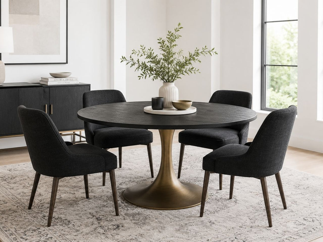 Round black dining table with four upholstered black chairs in a modern dining room.