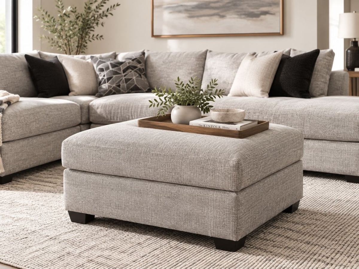 Light grey upholstered ottoman styled in a modern neutral living room, a versatile ottoman in Calgary for comfortable contemporary homes.