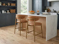 Tan leather counter stools at a marble kitchen island.
