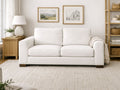 Cream upholstered sofa in a neutral living room with framed art and soft natural light.