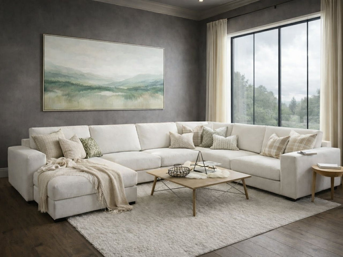White sectional sofa arranged in a bright, modern living room with a light wood coffee table and neutral decor.