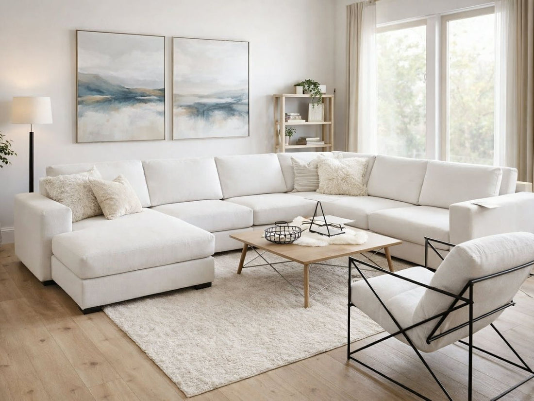 White sectional sofa arranged in a bright, modern living room with a light wood coffee table and neutral decor.