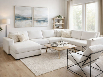 White sectional sofa arranged in a bright, modern living room with a light wood coffee table and neutral decor.