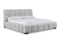 A modern upholstered bed with a plush, channel-tufted frame and padded headboard in a white background.