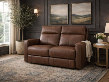 Warm brown reclining loveseat upholstered in genuine or faux leather, placed in a cozy, classic living room setting.