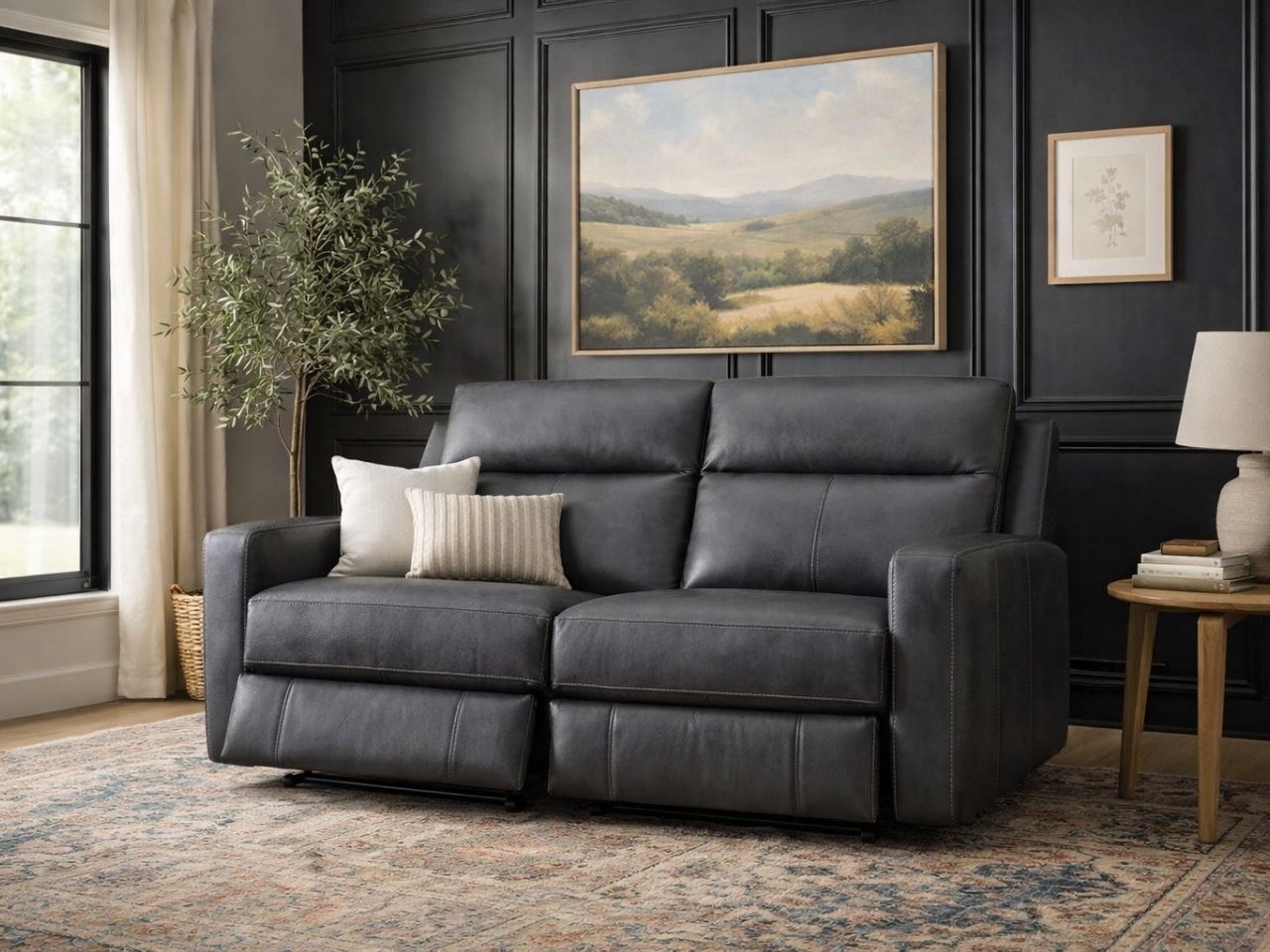 Modern dark gray reclining loveseat upholstered in smooth leather or leather-look fabric, set in a contemporary living room with dark paneled walls.
