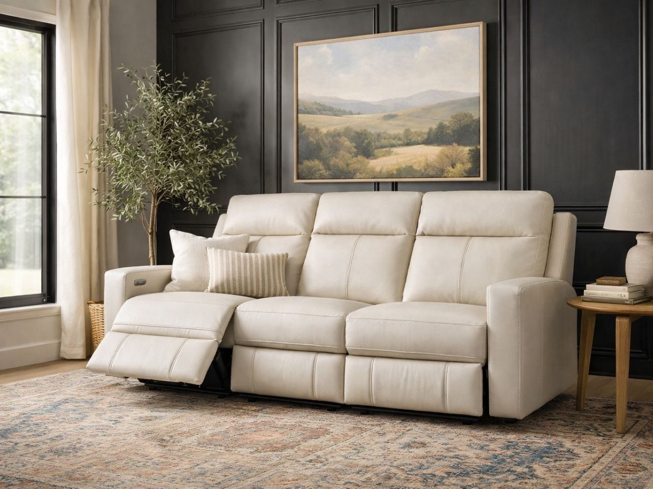 Cream leather reclining sofa with one seat extended, styled in a modern living room.