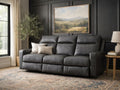 Dark gray leather reclining sofa in a modern living room with black paneled walls.