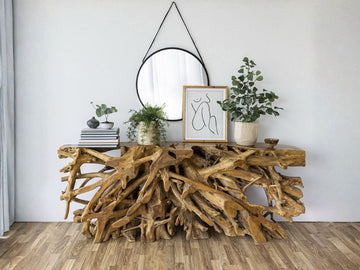 Natural wood root console table styled against a light wall in a home interior.