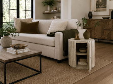 Light wood accent cabinet with a rounded fluted design and storage door, styled next to a cream sofa in a modern living room.