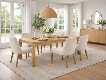 Wood extension dining table with upholstered chairs in a bright dining room.