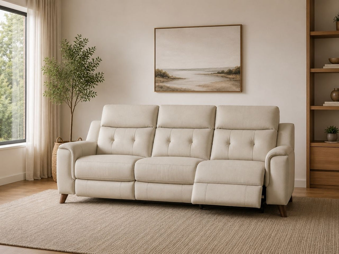 Cream-colored leather power reclining sofa with tufted back cushions in a modern neutral-toned living room.